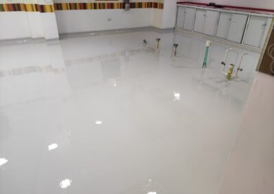 Piso epóxico sanitario instalado por GSA Ingeniería en área de lavado de cocina