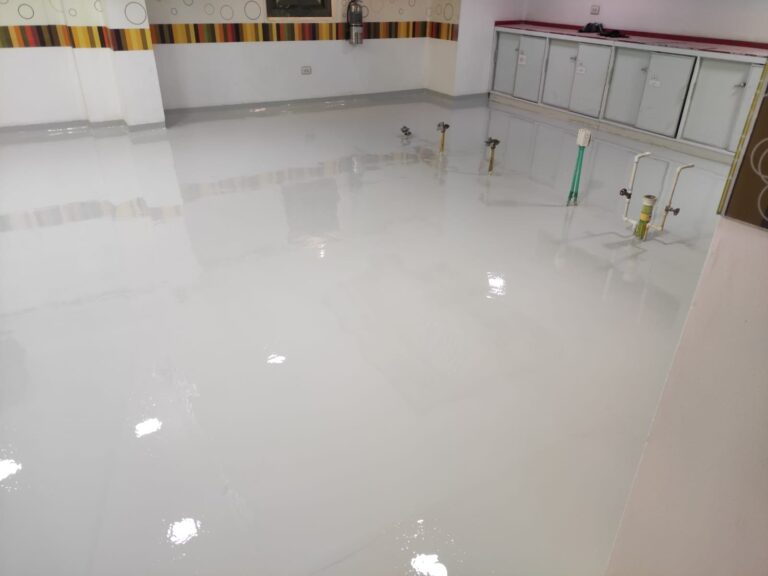 Piso epóxico sanitario instalado por GSA Ingeniería en área de lavado de cocina