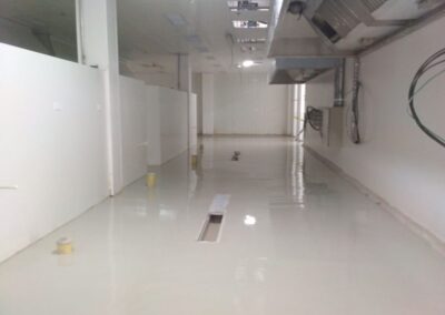 Zona de cocción bajo campanas con piso de poliuretano cemento en cocina industrial, GSA Ingeniería