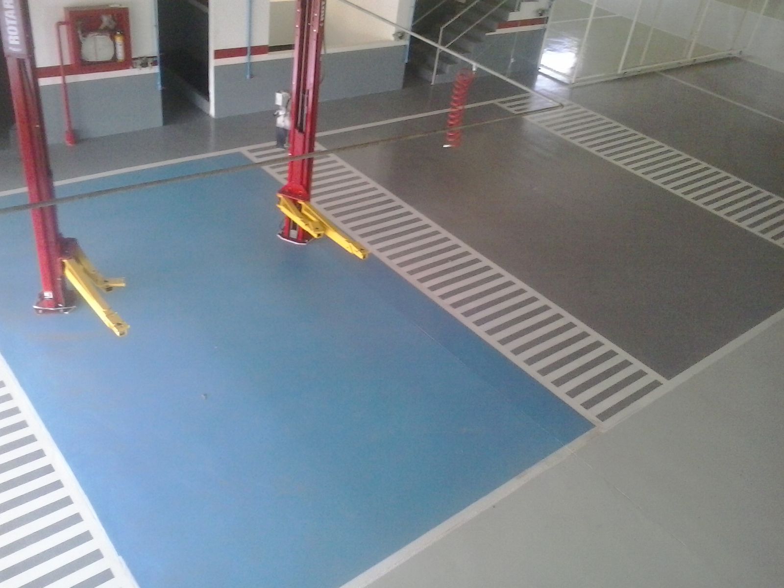 gsa-proyecto-concesionario-automotriz-vup-01 Bahía de servicio con piso epóxico azul y demarcación aplicado por GSA Ingeniería en concesionario de Valledupar