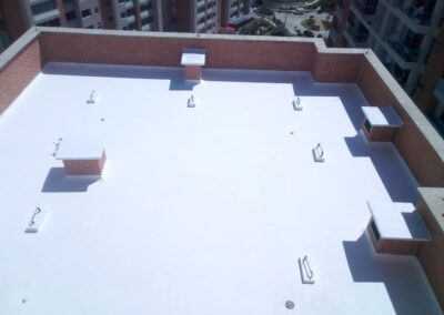 Impermeabilización acrílica reflectiva en cubierta de edificio residencial, aplicada por GSA Ingeniería