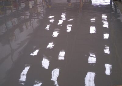 Piso de poliuretano-cemento aplicado por GSA Ingeniería junto a estanterías en fábrica de Cartagena