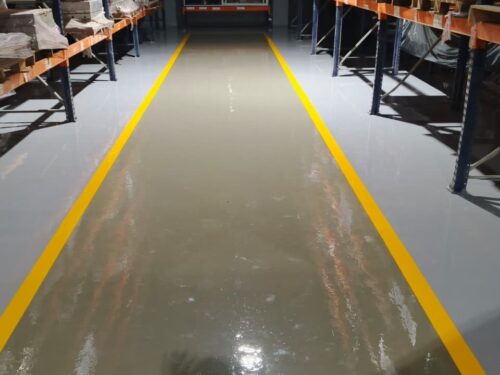 Taller de moldes con piso epóxico multicapa y demarcación amarilla aplicado por GSA Ingeniería en Barranquilla
