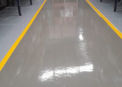 Pasillo demarcado con piso epóxico Danofloor ES PRO en fábrica de plásticos, obra de GSA Ingeniería