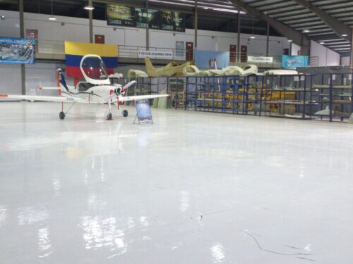 Hangar de aviación en Bogotá con piso epóxico Sikafloor-264 brillante, instalado por GSA Ingeniería