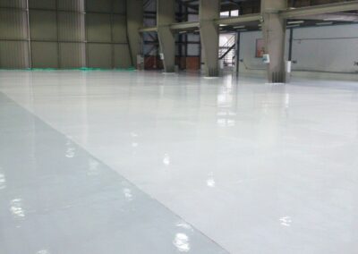 Detalle del acabado brillante de piso epóxico Sikafloor-264 en hangar, GSA Ingeniería