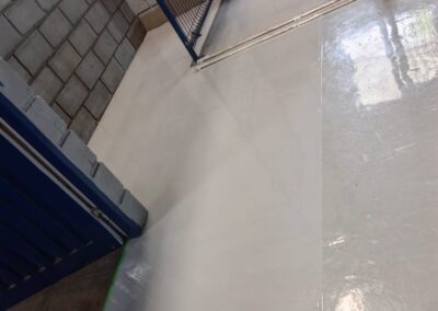 Pasillo entre jaulas de almacenamiento con piso epóxico Danofloor ES PRO instalado por GSA Ingeniería
