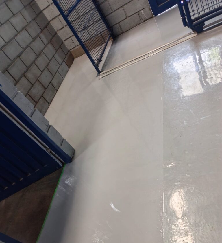 Pasillo entre jaulas de almacenamiento con piso epóxico Danofloor ES PRO instalado por GSA Ingeniería