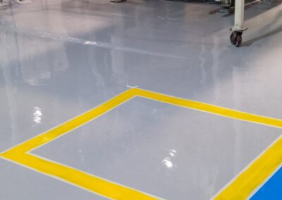 Zona demarcada con piso epóxico Danofloor ES PRO en planta de fabricación, obra de GSA Ingeniería