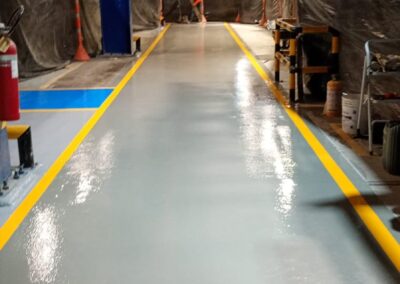 Pasillo largo con piso epóxico multicapa brillante instalado por GSA Ingeniería