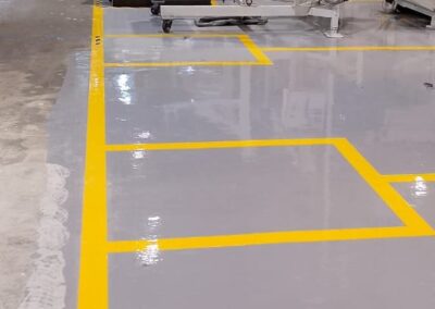 Pasillo peatonal demarcado sobre piso epóxico multicapa instalado por GSA Ingeniería