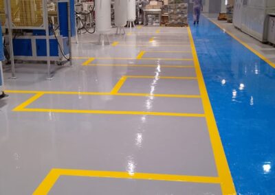 Piso epóxico Danofloor ES PRO con franjas de demarcación en planta de fabricación, obra de GSA Ingeniería