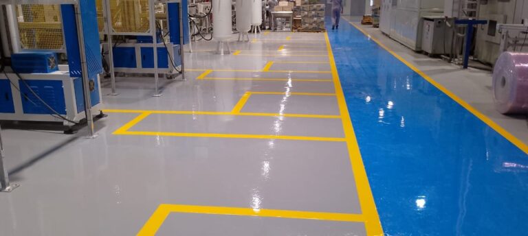 Piso epóxico Danofloor ES PRO con franjas de demarcación en planta de fabricación, obra de GSA Ingeniería