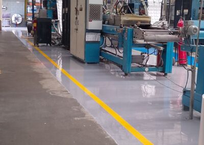Pasillo industrial con piso epóxico multicapa brillante aplicado por GSA Ingeniería