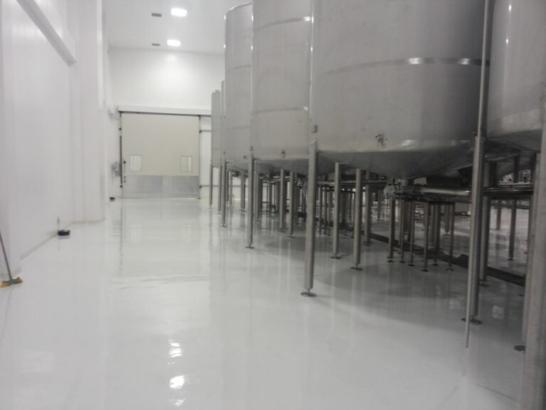 Piso epóxico sanitario terminado por GSA Ingeniería en zona de tanques de planta de alimentos