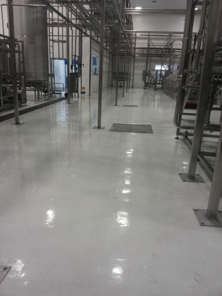 Pasillo con piso epóxico brillante aplicado por GSA Ingeniería en industria de alimentos