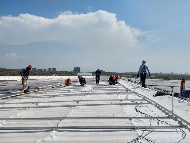 Cuadrilla de GSA Ingeniería instalando membrana PVC en cubierta industrial con paneles solares