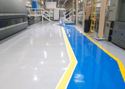 Pasillo peatonal demarcado sobre piso epóxico aplicado por GSA Ingeniería